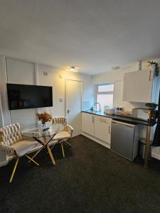 a kitchen with two chairs and a table in a room at Deluxe Town Centre Studio Stevenage in Stevenage