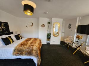ein Schlafzimmer mit einem großen Bett mit einer Faux-Felldecke in der Unterkunft Deluxe Town Centre Studio Stevenage in Stevenage