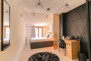 een slaapkamer met een bed en een bureau met een computer bij La Suite Neuvilloise in Neuville-sur-Saône