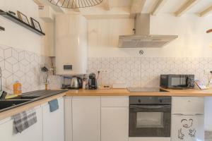 a kitchen with white cabinets and a counter top at La Suite Neuvilloise in Neuville-sur-Saône +26 photos