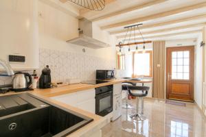 a kitchen with white cabinets and a counter top at La Suite Neuvilloise in Neuville-sur-Saône