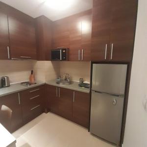 a small kitchen with wooden cabinets and a refrigerator at Апартамент Belvedere Е301 in Bansko