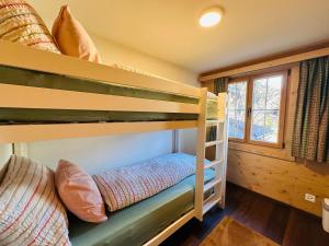 a bunk bed room with two bunk beds and a window at Chalet Solaria 2 bedrooms with mountain and garden view in Zweisimmen