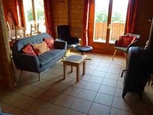 a living room with chairs and a couch and a table at Charmant chalet du Kohlberg in Dabo