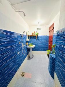 uma casa de banho com paredes pintadas de azul e um lavatório em Beach Cab Resort em Arugam Bay