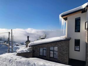 a building covered in snow with icicles on it at Hotel Abu in Gudauri