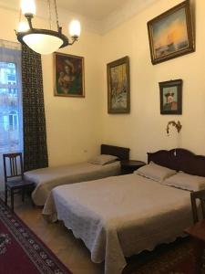 een slaapkamer met 2 bedden en een kroonluchter bij Gutsa Artists Mini-Hotel in Tbilisi City