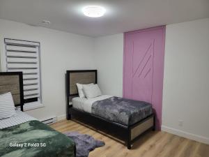 a bedroom with two beds and a pink door at Beau Séjour in Quebec City