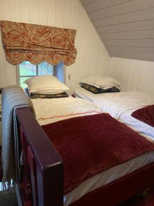 2 camas individuales en una habitación con ventana en La Maisonnette des Hêtres Rouges, en Spa