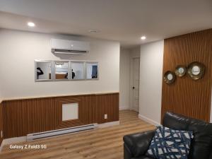 a living room with a couch and a tv at Beau Séjour in Quebec City