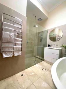 a bathroom with a shower and a sink and a mirror at Immaculate 3 Bed City Home - Close to Everything! in Sydney +52 photos