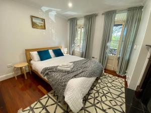 a bedroom with a large bed with blue pillows at Immaculate 3 Bed City Home - Close to Everything! in Sydney