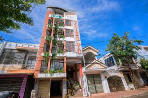 ein hohes Gebäude mit einem Schild drauf in der Unterkunft Triệu Vũ Hotel & Apartment in Buon Ma Thuot