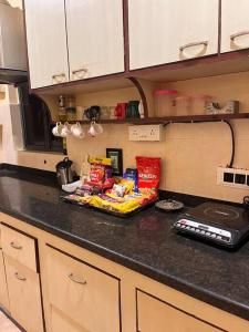 a kitchen counter with snacks on a counter top at Centrally located, big home in Kolkata