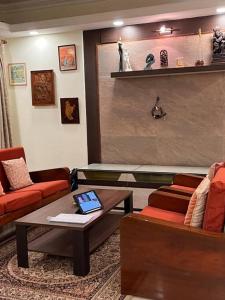 een woonkamer met een bank en een salontafel bij Centrally located, big home in Calcutta