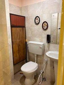een badkamer met een toilet en een wastafel bij Centrally located, big home in Calcutta