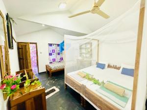 a bedroom with a bed and a ceiling fan at Beach Cab Resort in Arugam Bay