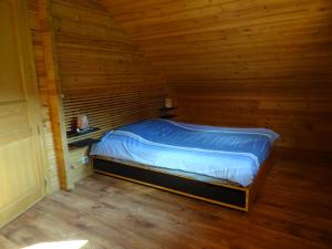 1 dormitorio con 1 cama en una cabaña de madera en Charmant chalet du Kohlberg, en Dabo