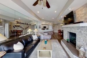 a living room with a leather couch and a fireplace at Waters Edge in Lake Ozark