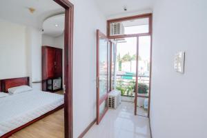 Triệu Vũ Hotel & Apartment في بون ما توت: غرفة نوم بسرير ومرآة كبيرة