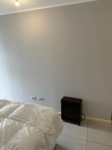 a white bedroom with a bed and a tv at Full equipado frente al mar 4307 in Los Molles