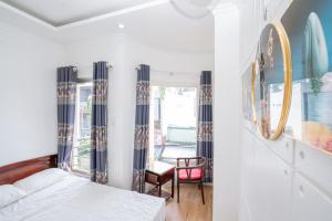 a bedroom with a bed and a chair at Triệu Vũ Hotel & Apartment in Buon Ma Thuot