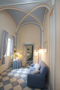 Zimmer mit einem blauen Sofa und einem Zimmer mit einem Bett in der Unterkunft Mondovì Ridente in Mondovì