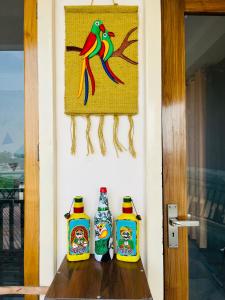 three bottles of ketchup on a table next to a door at wuiD stayin wakeupinDoon in Dehradun