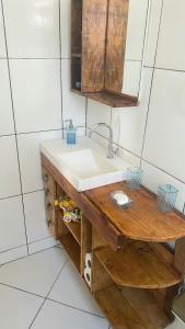 a bathroom with a sink and a wooden table at Suite Baia dos Corais in Angra dos Reis