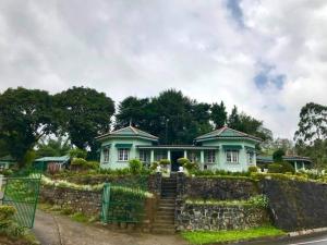 uma casa branca com uma cerca à frente. em Archu Agam em Kotagala