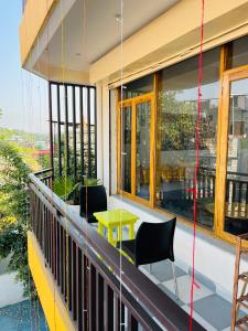 a balcony with chairs and a table on a building at wuiD stayin wakeupinDoon in Dehradun