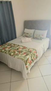 a bed with a blanket and pillows on it at Suite Baia dos Corais in Angra dos Reis
