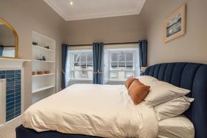 a bedroom with a bed and two windows at Home in Kelso Scottish Borders in Kelso