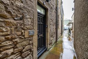 an alley with a black door on a stone building at Home in Kelso Scottish Borders in Kelso