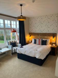 a bedroom with a bed and a couch and a chair at The Randolph Hotel in Southwold