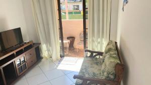 een woonkamer met een tv en een stoel bij Suite Baia dos Corais in Angra dos Reis
