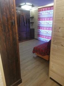 a door to a room with a bed and a closet at CASA MIRTILLO sci ai piedi in Prato Nevoso