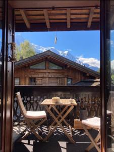 un patio con mesa y sillas y una cabaña en Appartement ensoleillé aux Tines, vue Massif en Chamonix-Mont-Blanc
