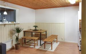 ein Esszimmer mit einem Tisch und Bänken in einem Zimmer in der Unterkunft 1 Bedroom Gorgeous Home In Torsby in Branäs