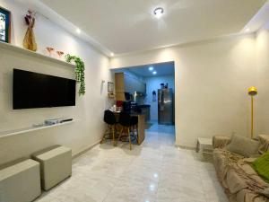 uma sala de estar com um sofá e uma televisão na parede em Agradable dormitorio en suite con estacionamiento privado em Ciudad del Este
