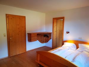 um quarto com uma cama e uma porta de madeira em Haus Joelblick em Oberau