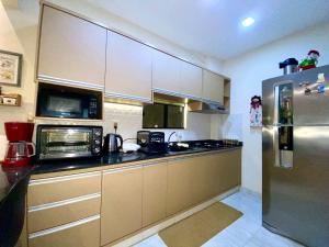 uma cozinha com um frigorífico de aço inoxidável e micro-ondas em Agradable dormitorio en suite con estacionamiento privado em Ciudad del Este