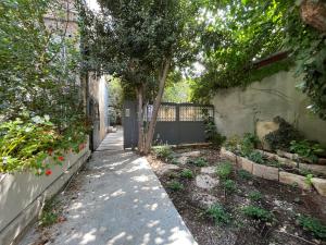 a garden with a tree next to a fence at Ruth Suite in Jerusalem