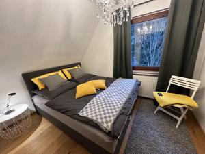 - une chambre avec un lit doté d'oreillers jaunes et d'une fenêtre dans l'établissement Haus Leni am Paulsberg, à Braunlage