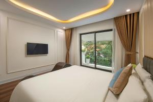 um quarto com uma cama grande e uma janela em ECO HOTEL em Hanói