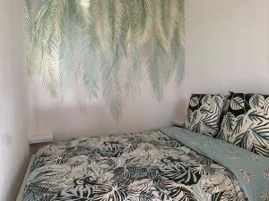 1 dormitorio con 1 cama y un mural de palmeras en Maisonnette dans belle résidence, en Saint-Vallier-de-Thiey