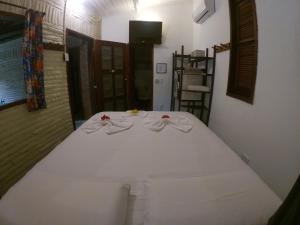 a white bed with three pairs of towels on it at Pousada Ibirapuera in Jericoacoara