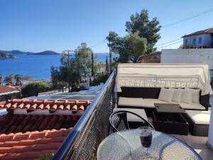 balcón con mesa, sillas y vistas al agua en Villa Nina en Skiathos