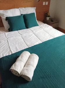 a large bed with two rolled up towels on it at Auberge de Mourjou in Mourjou
