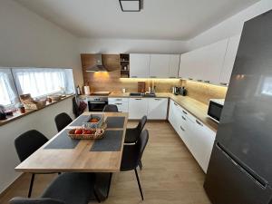 a kitchen with a table and chairs and a refrigerator at CHATA KVETINKA in Martin